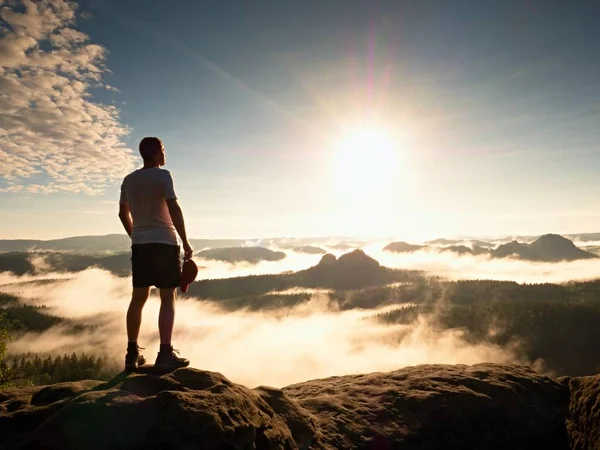 Turist med röda baseball cap Sportiga shorts stå på cliff edge — Stockfoto