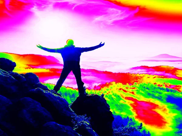 Infrared  photo. Man in sportswear on cliff edge