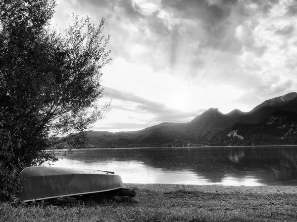 Vzhůru nohama pádlo rybářské lodi na břehu jezera Alp. Hladké levelof podzimní jezero. — Stock fotografie