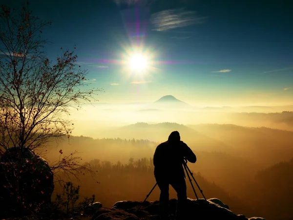 Soliga tidig vintermorgon. Fotograf förbereda kameran på stativ. — Stockfoto