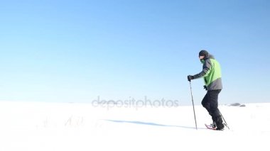 Kış Turizm karlı drift kar ayakkabıları yürüyüş ile. Yeşil spor ceket ve siyah pantolon toz karda snowshoeing trekking fiyatı. Bulutlu kış günü, nazik Rüzgar küçük kar pul getiriyor.. 