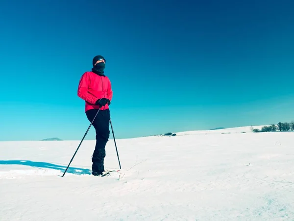 Turista invernale con ciaspole a piedi nella deriva innevata. Escursionista in giacca sportiva rosa — Foto Stock