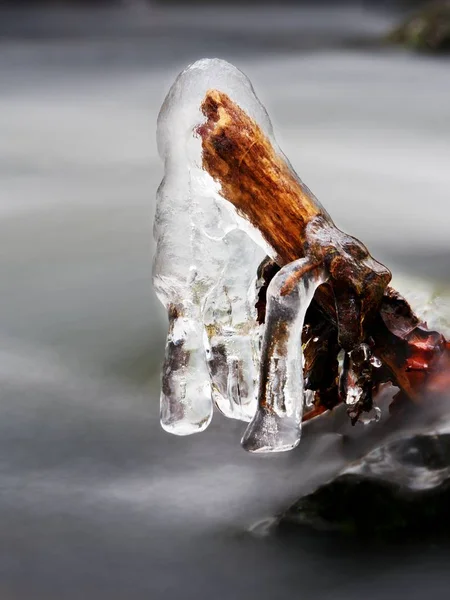 Eisglatte Äste über dem kalten Bach. Spiegelungen in Eiszapfen — Stockfoto