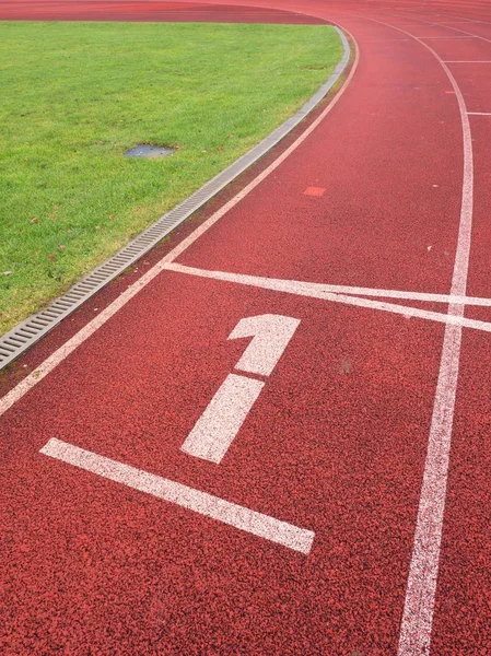 Número uno. Número de pista blanca en pista de carreras de caucho — Foto de Stock