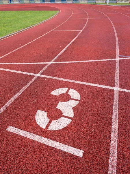 Número tres. Gran número de pista blanca en pista de carreras de caucho — Foto de Stock