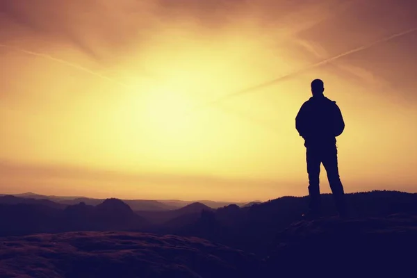 Un hombre tiene las manos en las caderas. Silueta deportiva en la naturaleza al amanecer — Foto de Stock