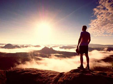 Kayalık tepe üzerinde kırmızı bere ile kal adamım. Üzerinde kayalık Zirvesi güneş güzel anı doğa mucizesi yürüyen adam. Vintage etkisi