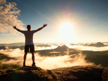 Dağ zirvesi. Mutlu bir adam jest kol kaldırdı.