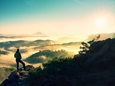 Adam uçurumun üzerinde tırmanma yüksek siluet. Zirveye kadar tırmandı hiker zevk görünümü.