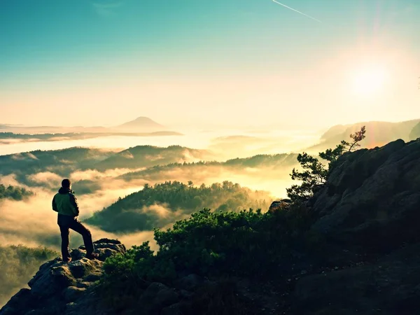 Hombre silueta escalando alto en el acantilado. Caminante subió a pico disfrutar de la vista . — Foto de Stock