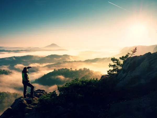 Man on top of mountain. Hiker climbed on peak of rock above foggy valley. — Stock Photo, Image