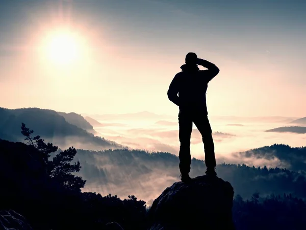 Man står hög på klippa. Hiker klättrade upp till rocky topp och njut av utsikten — Stockfoto