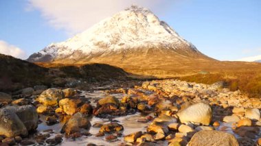 Güneşli kış sabah donmuş nehir Coupall Delta nehir Etive için de. Dağ Stob Dearg 1021 metre yüksek karlı koni. Higland İskoçya'da bir harika gün. Çim ve heather çalılar bankalar üzerinde kuru. 