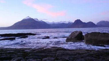 Elgol Bay Isle of Skye İskoçya'nın Batı kıyısında rüzgarlı bir gün batımı sırasında akşam. Soay karlı dağlardaki Hebrides, deniz üzerinde dalgalar kayalar için karşı çökmesini ada ve kaya keskin 
