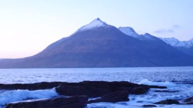 Elgol Bay Isle of Skye İskoçya'nın Batı kıyısında rüzgarlı bir gün batımı sırasında akşam. Soay karlı dağlardaki Hebrides, deniz üzerinde dalgalar kayalar için karşı çökmesini ada ve kaya keskin 