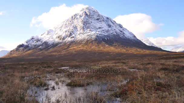 Mañana de invierno soleada en el río congelado Coupall en el delta hasta el río Etive. Cono nevado de montaña Stob Dearg 1021 metros de altura. Higland en Escocia un día maravilloso. Hierba seca y arbustos de brezo en bancos . — Vídeo de stock