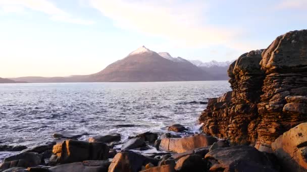Um minuto antes do pôr-do-sol no mar. Ondas colidindo com rocha afiada da Ilha de Skye, na Escócia. Nível do mar espumoso. Pedras pretas grandes arredondadas e pedra aguda acima do mar espumoso das Hébridas. Resort turístico . — Vídeo de Stock