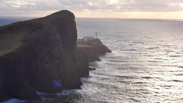 Beautiful sunrise on Neist Point, thin spit of land with famous lighthouse at the end. West coast of the Isle of Skye in Scotland . Shinning lighthouse above sea of the Hebrides. — Stock Video