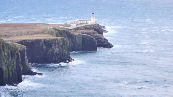 美しい Neist ポイント、薄い端には有名な灯台と土地の唾を吐きます。ハード風サンセットの内でスコットランドのスカイ島の西海岸。ヘブリディーズ諸島の海の上に輝く灯台. — ストック動画