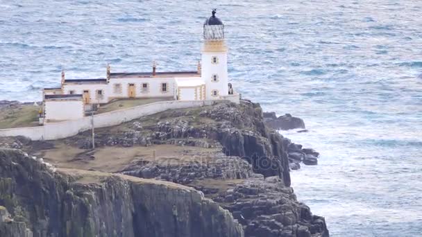 Beautiful sunrise on Neist Point, thin spit of land with famous lighthouse at the end. West coast of the Isle of Skye in Scotland . Shinning lighthouse above sea of the Hebrides. — Stock Video