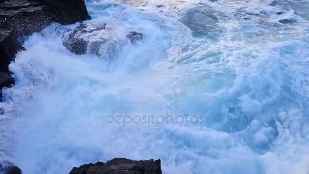 Große starke Wellen, die gegen den scharfen Felsen der Insel Skye in Schottland krachen. schäumender Meeresspiegel. abgerundete große schwarze Steine und scharfer felsiger Turm über dem schäumenden Meer der Hebriden. Touristenort. — Stockvideo