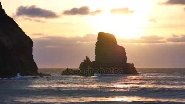 Ilta Talisker lahdella länsirannikolla Isle of Skye Skotlannissa aikana tuulinen auringonlasku. Terävä kivinen torni Hebridien vaahtomaisen meren yllä, aallot törmäävät lohkareisiin ja terävään kiveen — kuvapankkivideo