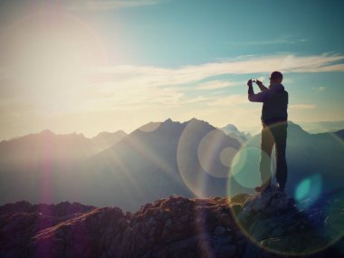 Mercek parlaması. Uzun yürüyüşe çıkan kimse selfie fotoğrafı çeker. Turistik zirve