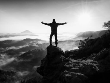 Adam uçurumun üzerinde tırmanma yüksek siluet. Zirveye kadar tırmandı hiker zevk görünümü.