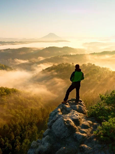 Adam dağın zirvesinde. Uzun yürüyüşe çıkan kimse rock sisli vadinin yukarıda zirvesine tırmandı. — Stok fotoğraf