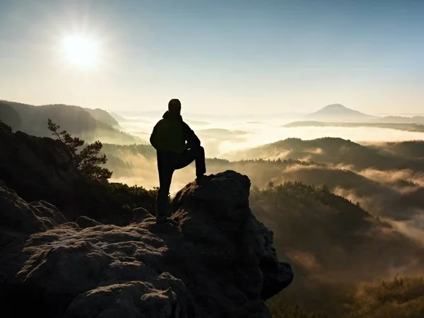 A silhueta do homem fica no pico da rocha afiada. Satisfazer caminhante desfrutar de vista . — Fotografia de Stock