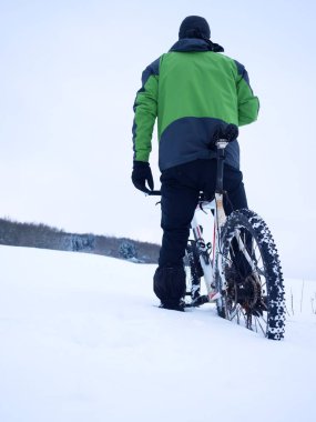 Adam dağ bisikleti ile kalın toz karda.