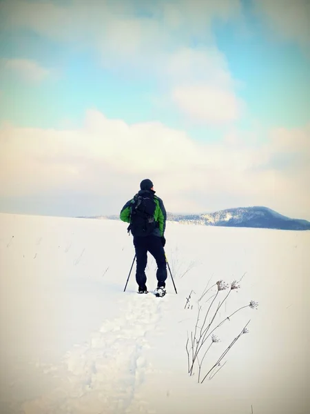 L'uomo con le ciaspole si riposa sulla neve. Escursioni con le ciaspole — Foto Stock