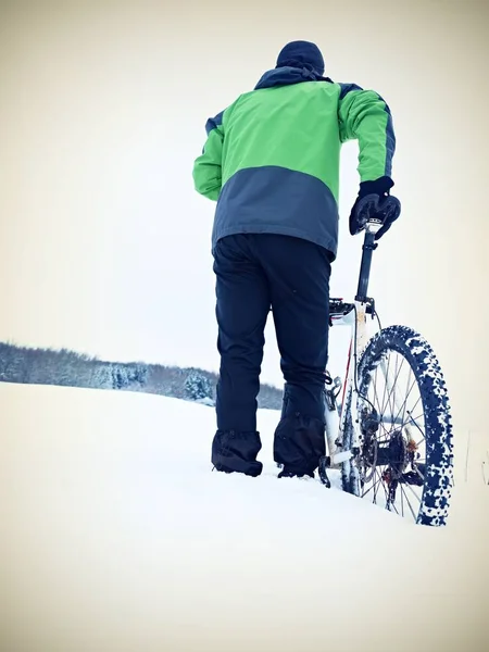 Hombre con bicicleta de montaña estancia en nieve en polvo . — Foto de Stock