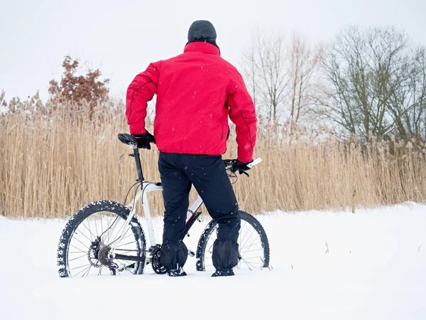 Desportista com bicicleta de montanha perdida na neve. Inverno no campo . — Fotografia de Stock