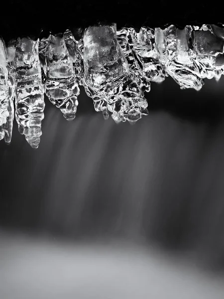 Icicles cuelgan de ramitas y corteza helada por encima de chile rápido arroyo . — Foto de Stock