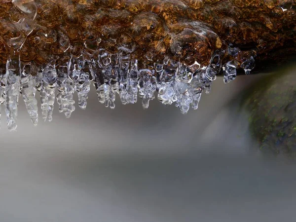 Зимовий струмок з бурульками над замерзлим гірським потоком. Зимовий сезон — стокове фото