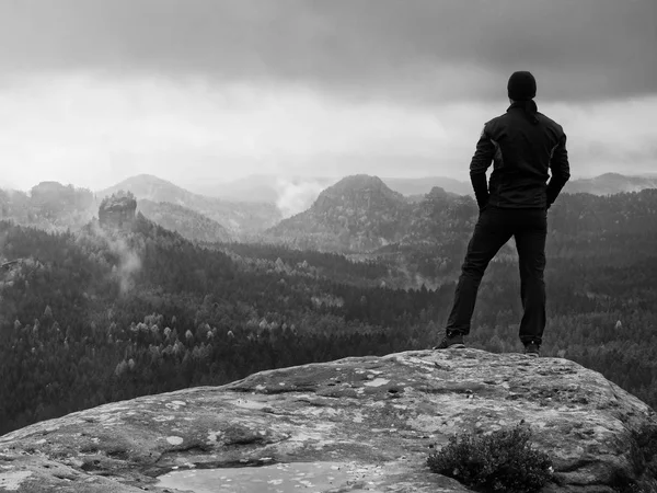 Hiker on rock end above valley. Man watch over misty and foggy valley — Stock Photo, Image