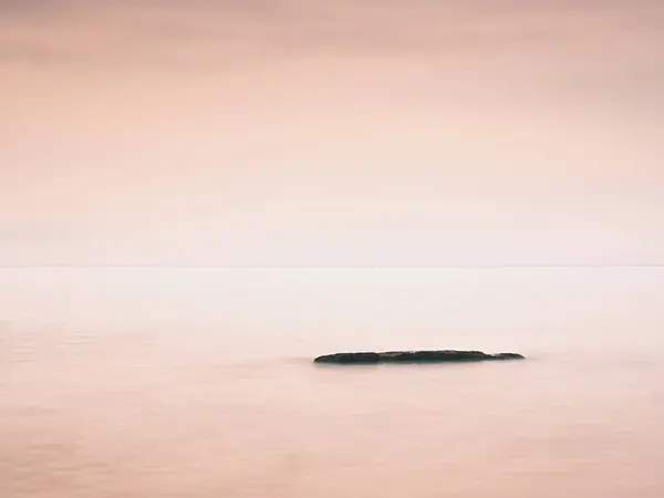 Romantische zee. Boulder stok uit uit glad golvende zee. — Stockfoto