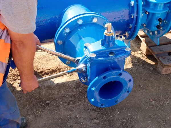 Robotnik ręce wkręcania nakrętki na nowe dring wody rurociągów. — Zdjęcie stockowe