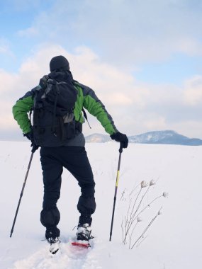 Kar ayakkabılarını adamla karda bir dinlenme al. Snowshoeing fiyatı