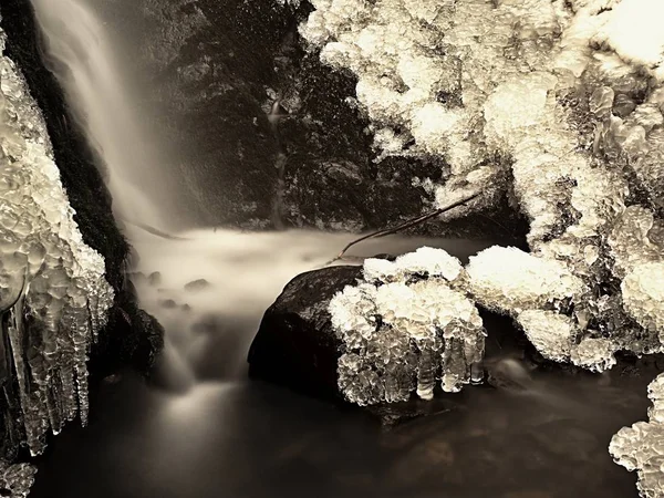 Замороженный водопад. Зимний ручей, ледяные камни и ветви — стоковое фото