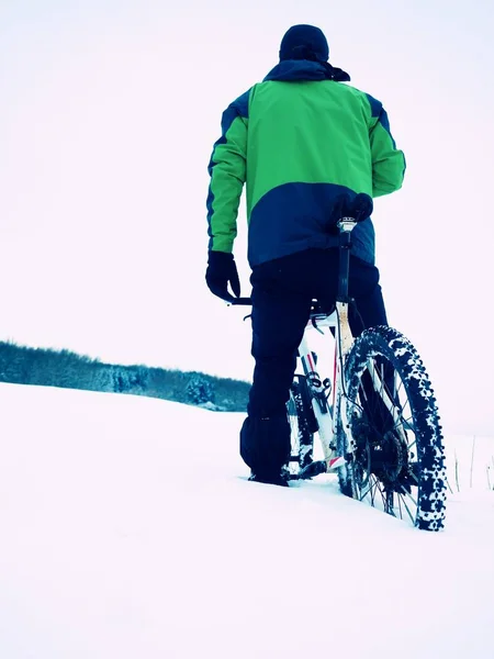 Adam dağ bisikleti ile kalın toz karda. — Stok fotoğraf