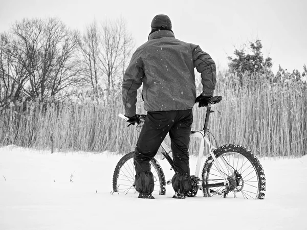 Deportista con bicicleta de montaña perdida en la nieve. Invierno en el campo . — Foto de Stock