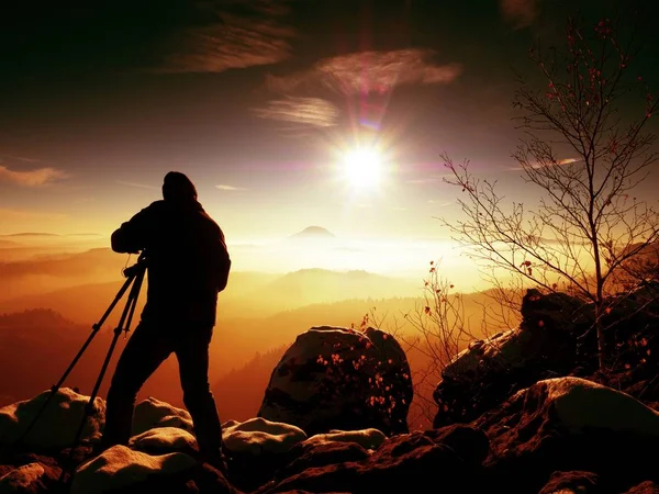 Photographer takes picture of freeze rocks covered with fresh powder snow. — Stock Photo, Image