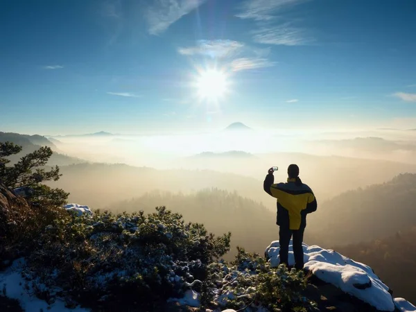 Photographer by smart phone takes picture of misty hilly landscape — Stock Photo, Image