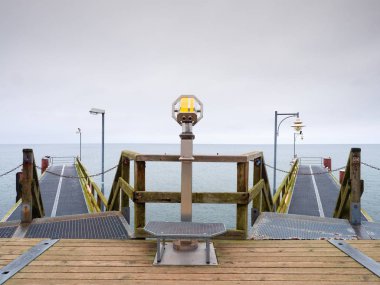 Seaside teleskop. Ahşap iskele sisli sonbahar sabahı 