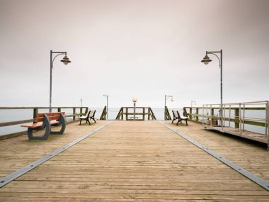 Seaside teleskop. Ahşap iskele sisli sonbahar sabahı 