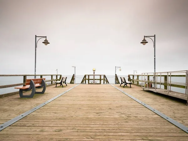 Telescopio Seaside. Mattina nebbiosa autunnale sul molo di legno — Foto Stock