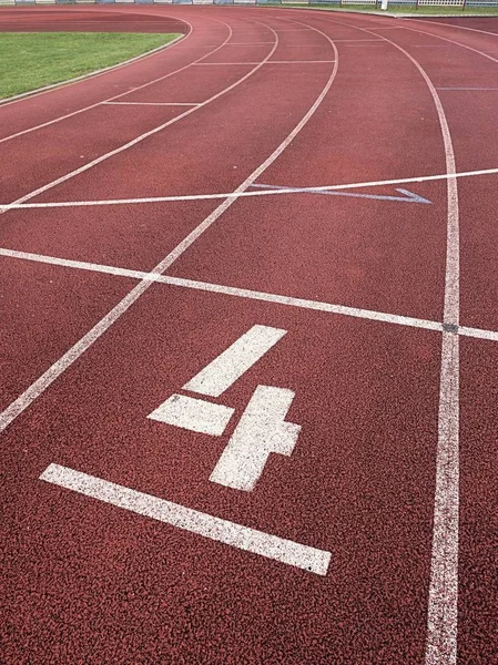 Número cuatro. Número de pista blanca en pista de carreras de caucho , — Foto de Stock