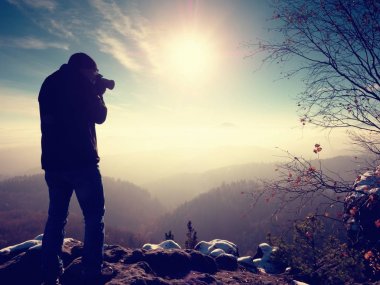 Uzun boylu adam boyunda ayna kamerayla fotoğraf çekiyorum. Karlı kaya